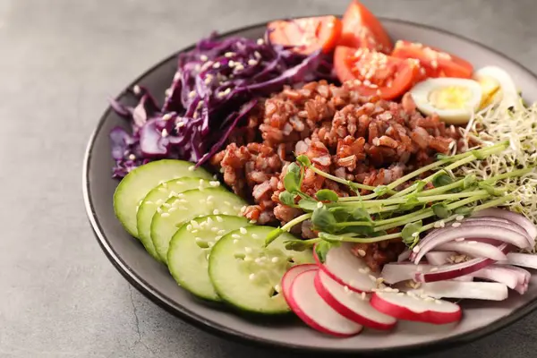 Gri masada kahverengi pirinçli lezzetli salata, yakın plan.