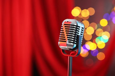 Kırmızı perdeye karşı bir klasik mikrofon, mesaj için yer. Bokeh etkisi