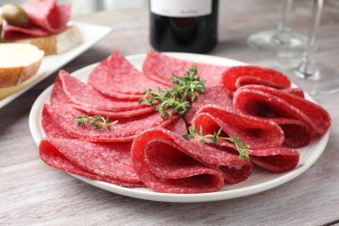 Hafif ahşap masada servis edilen kekik dilimli lezzetli sosisler.