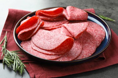 Gri masada servis edilen lezzetli sosisler, yakın plan.