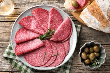 Tahta masada servis edilen biberiyeli leziz sosis dilimleri.