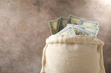 Renkli arka planda dolar banknotları olan çanta, yakın plan. Metin için boşluk
