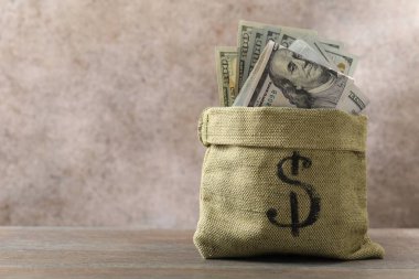 Tahta masanın üzerinde dolar banknotları olan çanta, metin için yer