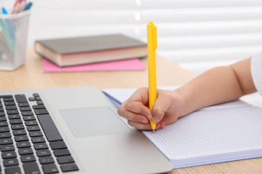 Küçük kız ev ödevlerini içeride yapıyor, yakın plan.