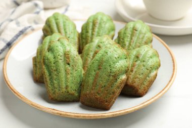 Lezzetli Matcha Madeleine kekleri beyaz masada, yakın plan.