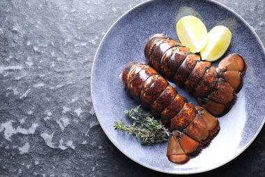 Çiğ ıstakoz kuyruğu, kireç ve kekik karanlık masa, üst manzara. Metin için boşluk