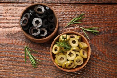 Farklı lezzetlerde marine edilmiş zeytin halkaları ve ahşap masada biberiye.