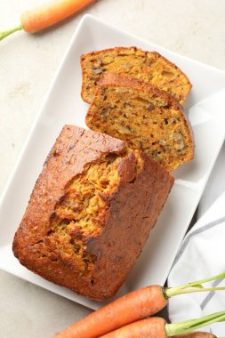 Açık gri masada fındıklı ve sebzeli ev yapımı havuçlu kek.