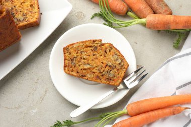 Açık gri masada fındıklı ve sebzeli ev yapımı havuçlu kek.