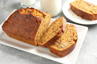 Ev yapımı havuçlu kek, fındıklı ve sütlü gri masa, yakın plan.