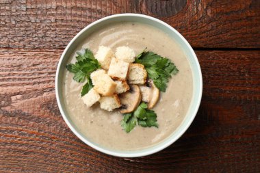 Ekmek arası mantar kremalı çorba ve ahşap masada maydanoz.