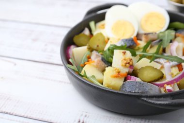 Ringa balıklı lezzetli salata, yumurta ve sebzeler beyaz ahşap masada, yakın plan. Metin için boşluk