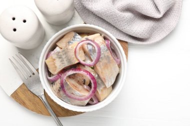 Beyaz masadaki soğanlı lezzetli ringa balıkları.