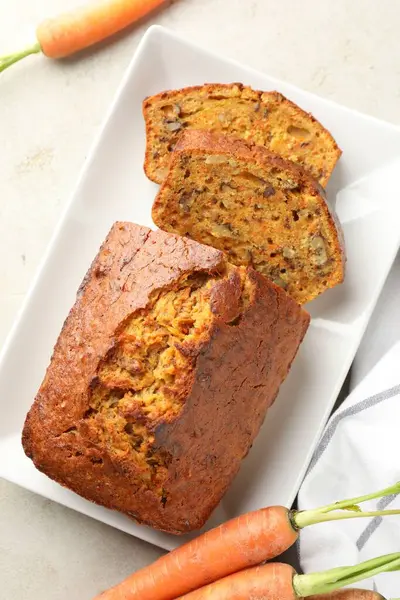 Açık gri masada fındıklı ve sebzeli ev yapımı havuçlu kek.