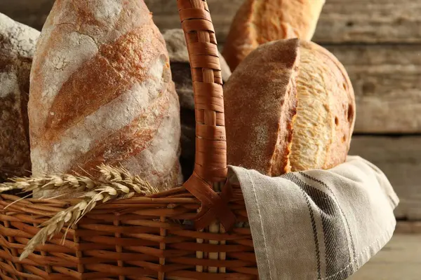 Farklı somunlar taze ekmek ve sepette çiviler, masada, yakın plan.