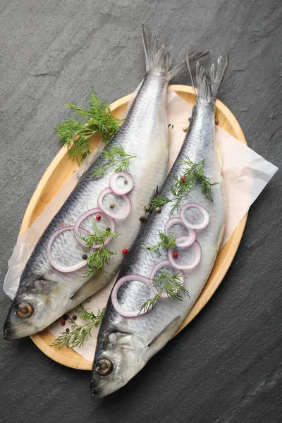 Lezzetli ringa balıkları, siyah masa üzerinde baharatlar, üst manzara.