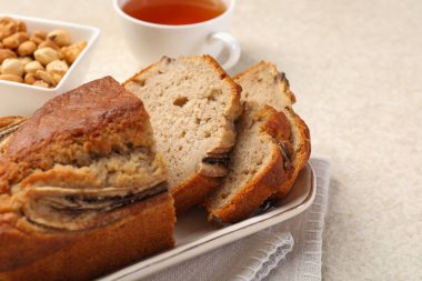 Muzlu ekmeği fındıklı kes ve açık gri masada çay, yakın plan.