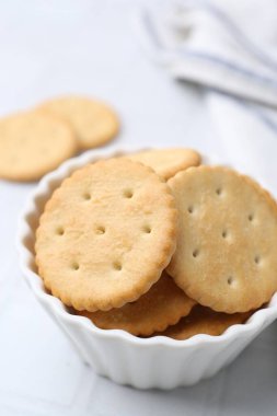 Beyaz fayanslı masada lezzetli tuzlu krakerler, yakın plan.