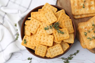 Lezzetli tuzlu kraker ve kekik beyaz masada, düz yerde.