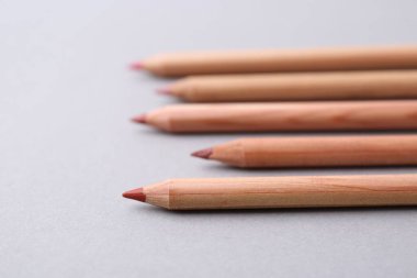 Açık gri arkaplanda pek çok farklı dudak kalemi, yakın plan