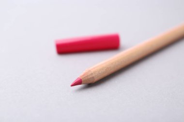 Açık gri arkaplanda güzel bir dudak kalemi, yakın plan.