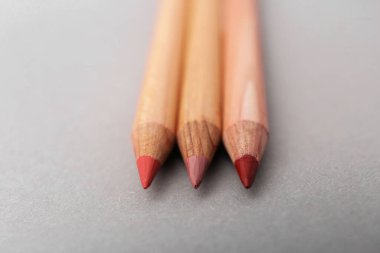 Açık gri arkaplanda pek çok farklı dudak kalemi, yakın plan