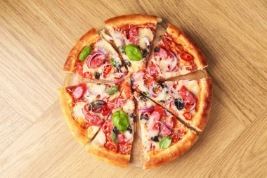 İnce füme sosisli, ahşap masa manzaralı lezzetli bir pizza.