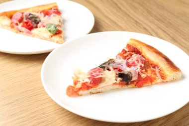 Ahşap masada servis edilen ince füme sosisli, lezzetli pizza dilimleri.