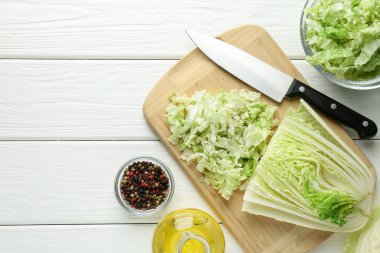 Beyaz ahşap masada Çin lahanası ve bıçak kes, düz yat. Metin için boşluk