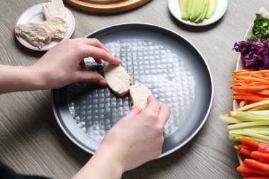 Gri ahşap masada nefis börek yapan kadın, yakın plan.