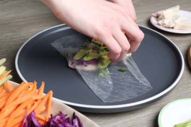 Gri ahşap masada nefis börek yapan kadın, yakın plan.