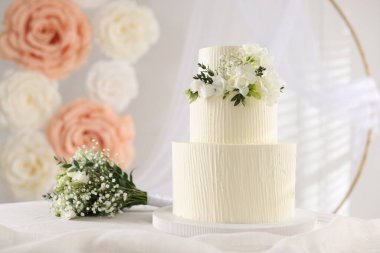 Çiçekli düğün pastası ve kapalı masa desenli lezzetli bir pasta.