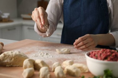 Khinkali yapıyorum. Mutfaktaki masada hamur şekillendiren kadın, yakın plan.