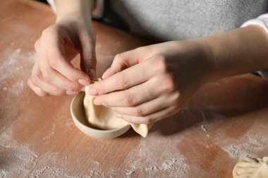 Mutfaktaki masada khinkali yapan kadın, yakın plan.