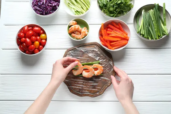 Beyaz ahşap masada nefis börek yapan bir kadın.
