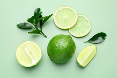 Taze limon ve yapraklar soluk yeşil arka planda, düz yatıyordu.