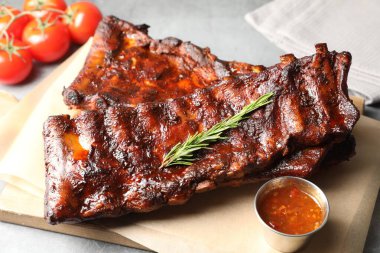 Biberiyeli, domatesli ve açık gri masadaki soslu domuz pirzolası. Yakın plan.