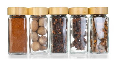 Beyaz kavanozlardaki farklı aromatik baharatlar.