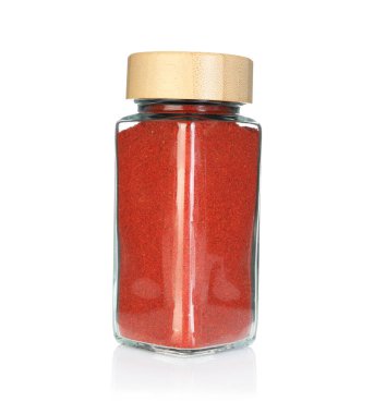 Baharat kavanozundaki kırmızı biber tozu beyaza izole edilmiş.