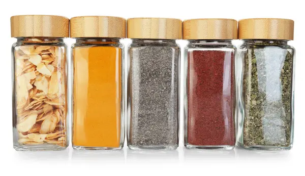 Beyaz kavanozlardaki farklı aromatik baharatlar.