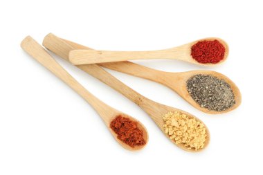 Beyaz kaşıklardaki farklı aromatik baharatlar.