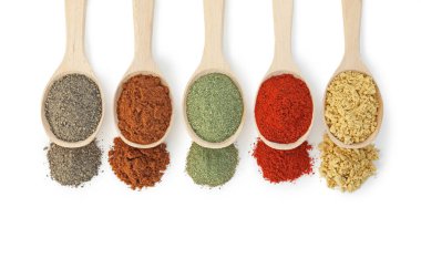 Beyaz, üst görünümde izole edilmiş kaşıklardaki farklı aromatik baharatlar