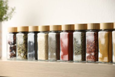 Kapalı alandaki ahşap raflarda farklı aromatik baharatlar.