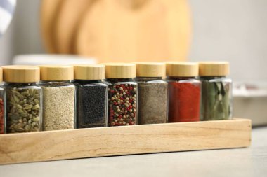 Işık masasındaki kavanozlarda farklı aromatik baharatlar, yakın plan.