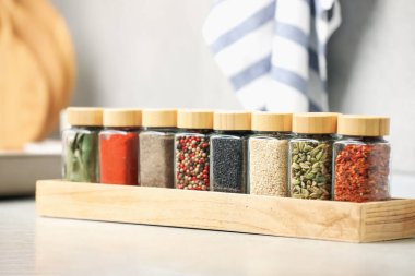 Işık masasındaki kavanozlarda farklı aromatik baharatlar, yakın plan.