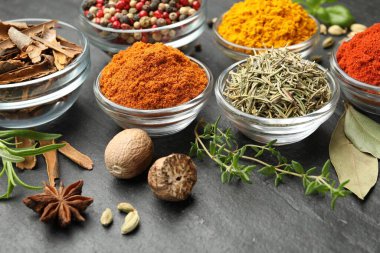 Gri masada farklı aromatik baharatlar, yakın plan.