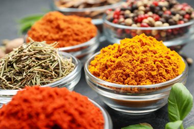 Gri masada farklı aromatik baharatlar, yakın plan.