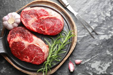 Çiğ et, baharat ve çatal. Koyu masada, düz yerde. Metin için boşluk