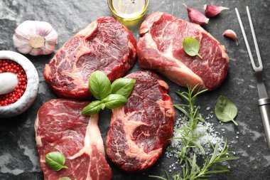 Çiğ et, baharat ve çatal. Koyu masada, düz yerde.