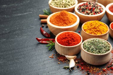 Siyah masada farklı aromatik baharatlar, yakın plan. Metin için boşluk